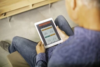 Man met de Evohome app op een tablet